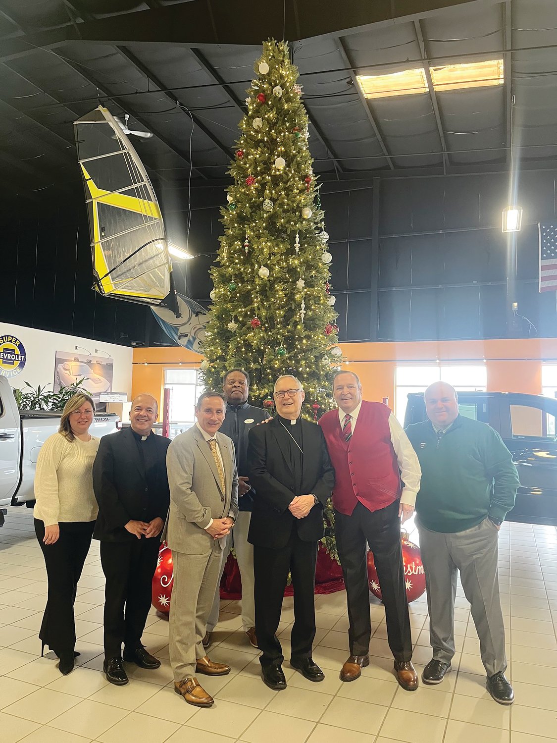 Bishop Thomas J. Tobin visits Paul Masse Chevrolet in East Providence on Dec. 6, to receive a generous donation from the Masse family and company to help ‘Keep the Heat On’ and to assist many other ministries in the Diocese of Providence through the Catholic Charity Appeal and the Diocesan Assistance Fund. Pictured from left, Office Manager Kelly Gaulin, Pastor of St. Thomas More Church Father Marcel Taillon, President Scott Wellington, BDC Representative Farris Maxwell, Bishop Thomas J. Tobin, Founder and Chairman Paul Masse, and Vice President Bob Masse.
